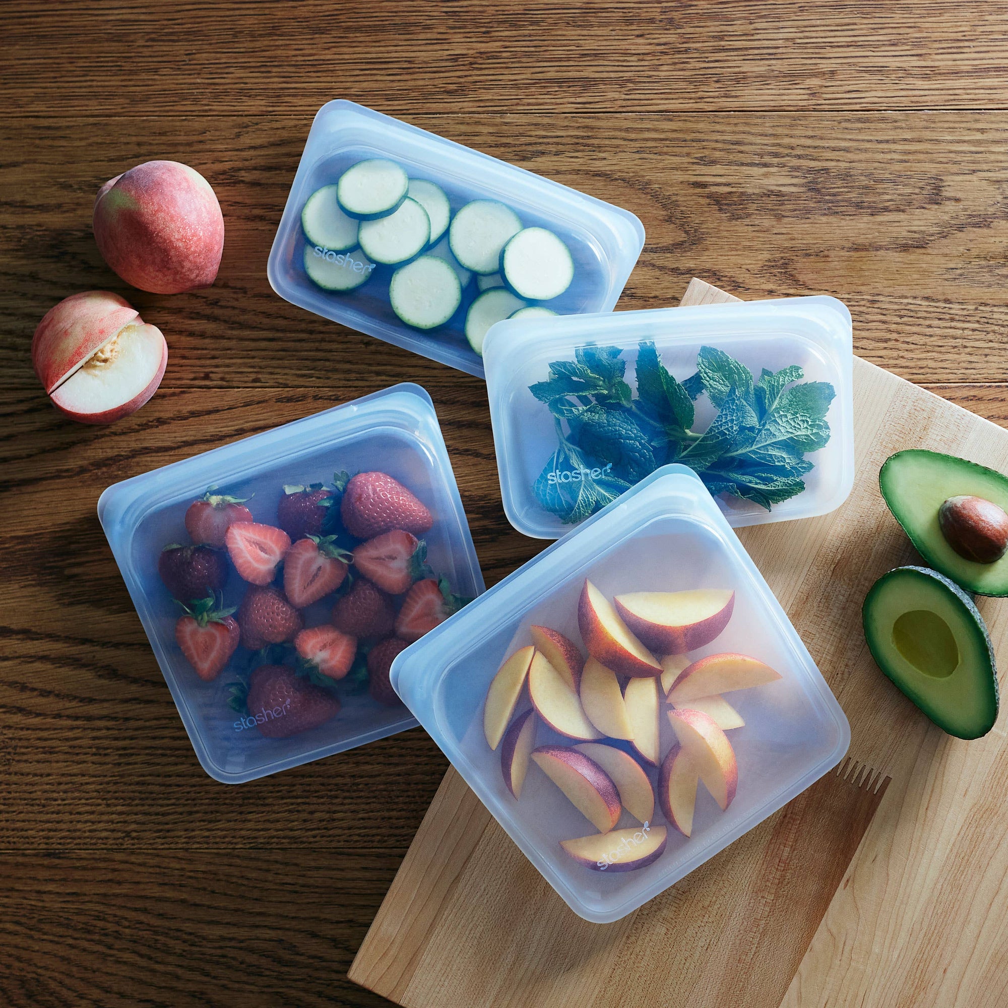 Stasher snack size reusable silicone storage bag with clear body and green seal, perfect for snacks and small items.