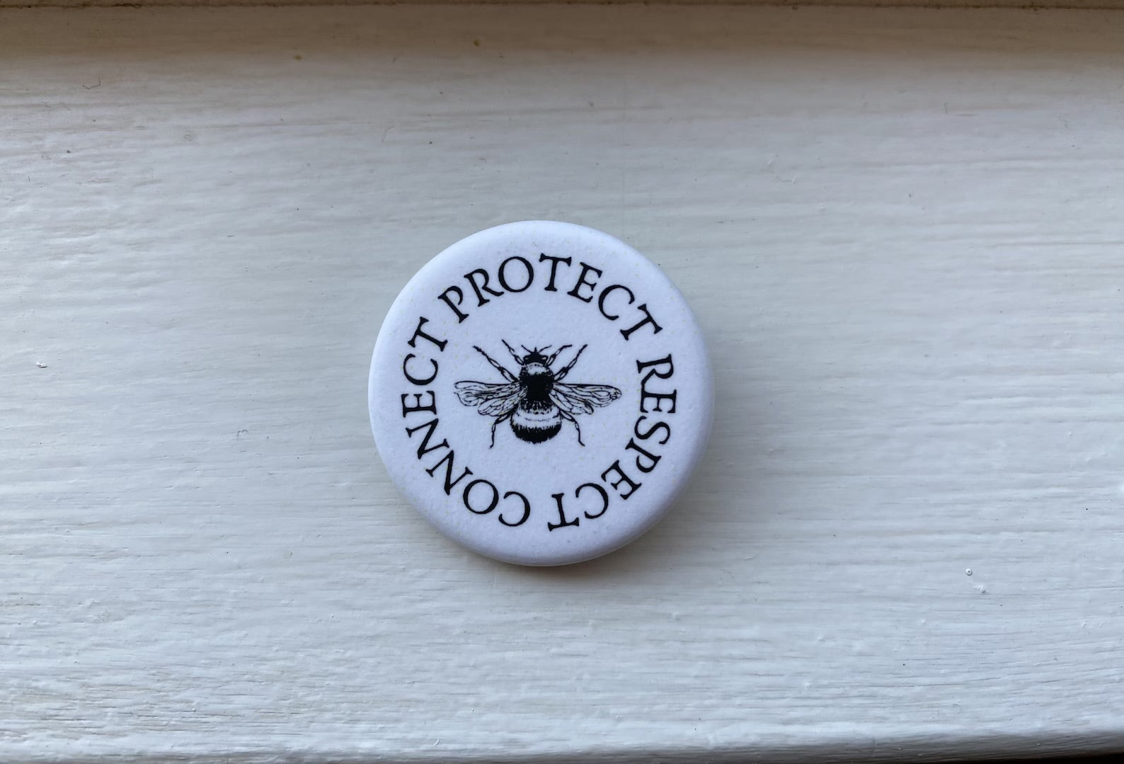 Off the Bottle Refill Shop Freethinker Paper Co buttons featuring colorful, round designs on a white background.