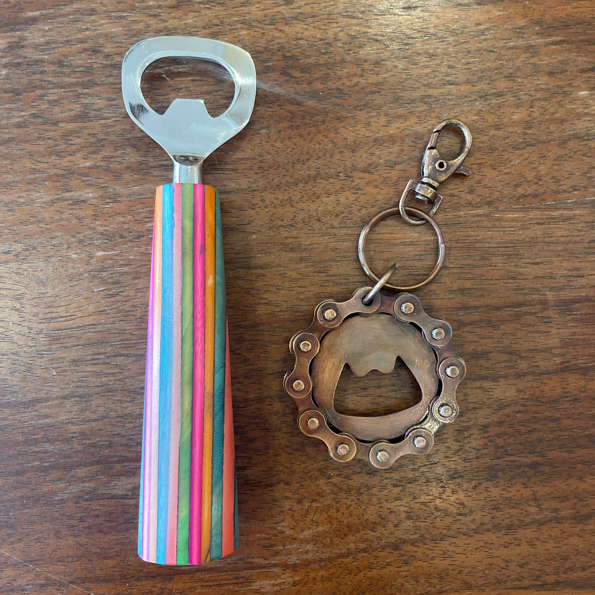 Off the Bottle Refill Shop Ten Thousand Villages bottle opener made of metal with a wooden handle, displayed on a white background.