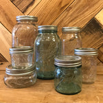 Clear glass Ball Mason jars with metal lids, ideal for storage or canning, showcasing their classic design and sturdy build.