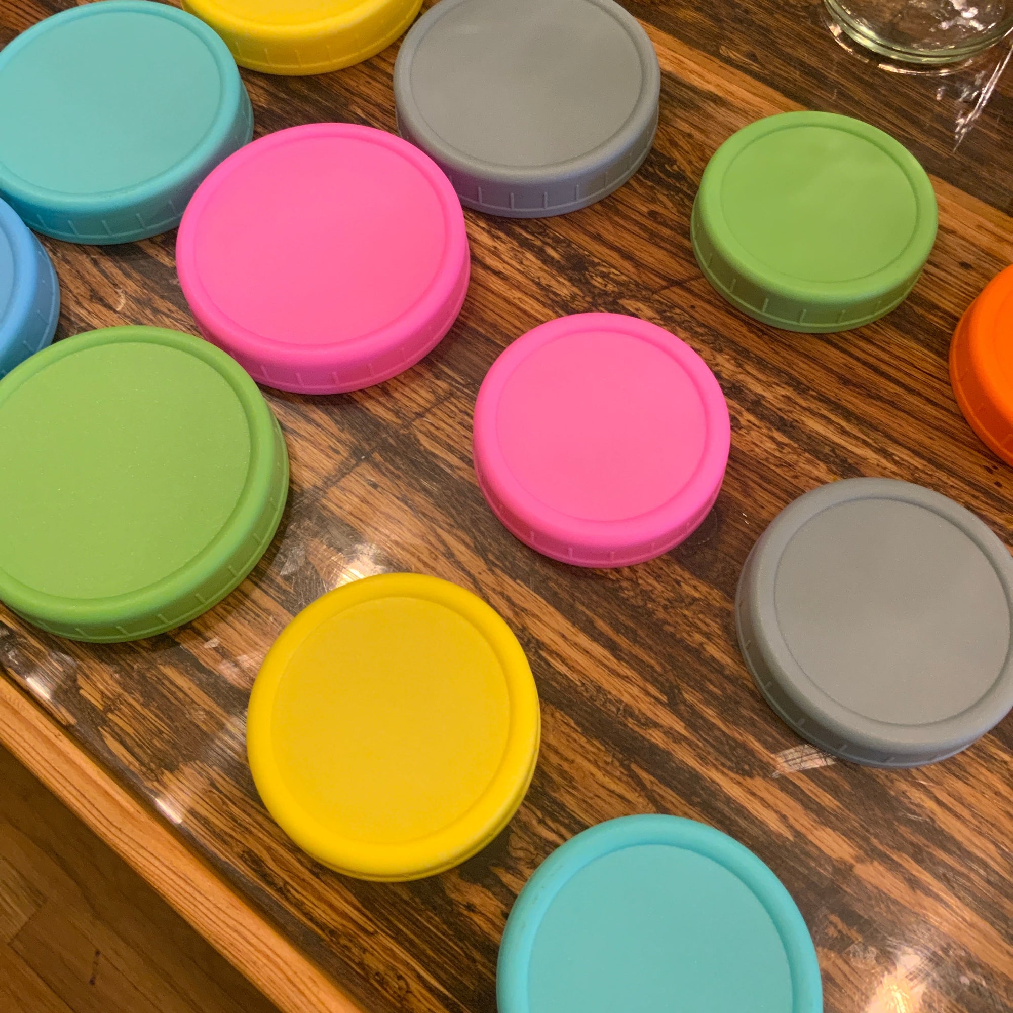 Assorted plastic mason jar lids from OTB Refills, variety of sizes and colors for sealing mason jars.